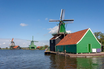 Fototapeta na wymiar Dutch green sawmill at the edge of river facing the wind and reading for servicing