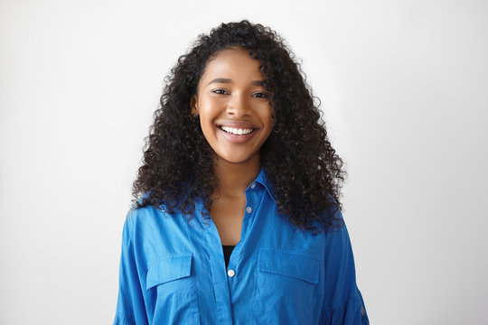 Human facial expressions, emotions, feelings and reaction. Portrait of happy joyful young mixed race woman with perfect glowing skin and charming smile enjoying good day, posing in white studio