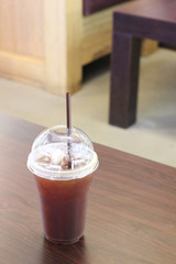 Black coffee with ice on table in cafe.
