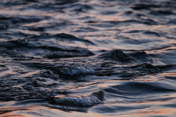 Beautiful sunset reflection view with river flowing with small waves.