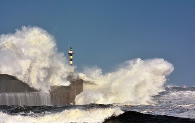 Fototapeta na wymiar Stormy wave over lighthouse of San Esteban de Pravia.