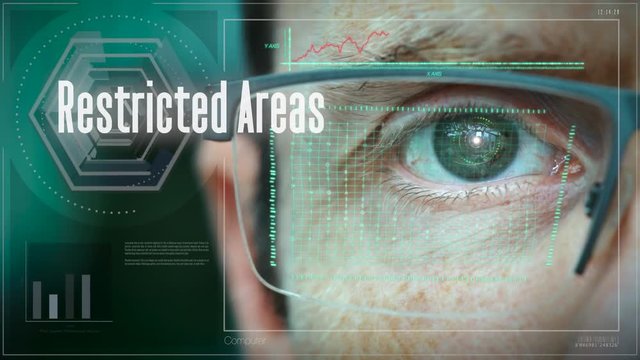 A close up of a businessman eye controlling a futuristic computer system with a Restricted Areas concept.