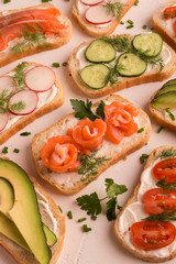 Sandwiches with salmon, cucumber, tomatoes, avocados and greens, vegetable sliced