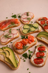 Sandwiches with salmon, cucumber, tomatoes, avocados and greens, vegetable sliced
