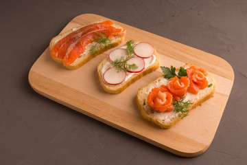 Sandwiches with salmon, cucumber, tomatoes, avocados and greens, vegetable sliced
