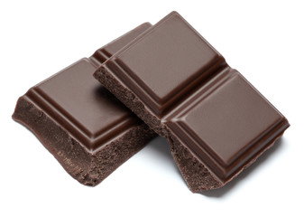 Dark organic chocolate pieces isolated on white background