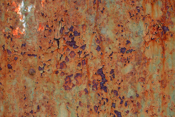 Textured background cracked green paint on an old rusty metal surface.