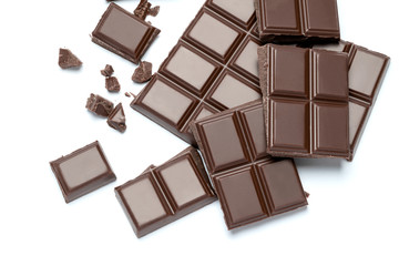 Dark organic chocolate pieces isolated on white background