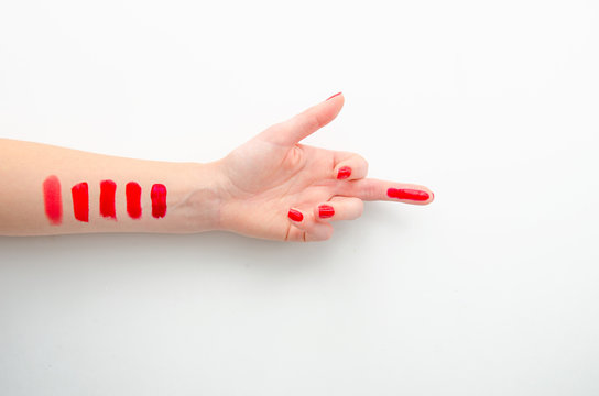 Lipstick Makeup Swatches On Female Hand, Flat Lay. Red Lipstick On The Middle Finger