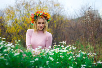 Girl in a wreath of autumn leaves In flowers