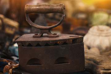 macro old coal iron on countertop in sunday flea market. Antique bazaar