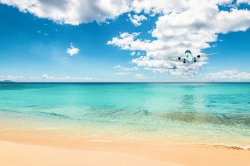 Airliner in the distance above the beautiful Caribbean ocean, will land at Maho beach of Sint Maarten.