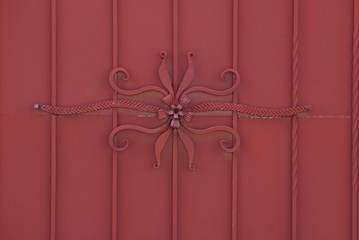 red metal texture wrought iron pattern on an iron fence wall