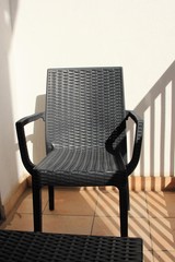 Wicker black chair on the balcony.