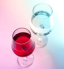 A glass of wine and a glass of water. Pink and blue shades. Close-up. View from above.