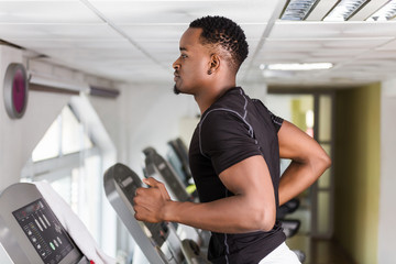 Black African American  young man doing cardio workout at the gym