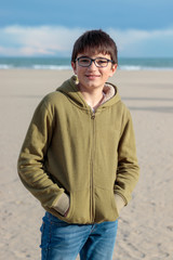young man with glasses looking at camera on the beach