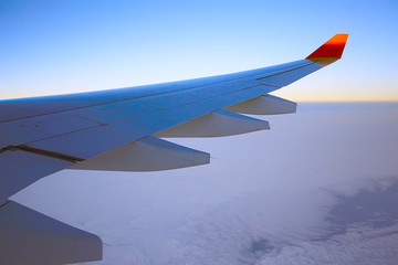 Obraz premium wing airplane view of sky / blue sky and wing of an airplane, view from the cabin of an airplane, concept of air transport