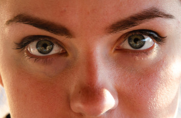 Naklejka premium Face, girl's eyes near, close-up on a sunny spring day