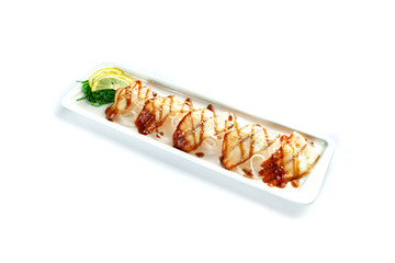 pieces of white fish with lemon and herbs on a rectangular plate on an isolated white background