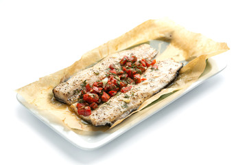 baked fish fillet with paprika on an isolated white background