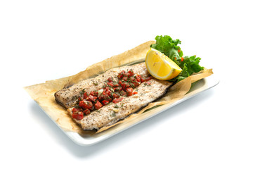 baked fish fillet with paprika and lemon on an isolated white background
