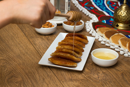 Pouring honey on Qatayef - Traditional middle eastern sweets , usually eaten in Muslims holy month : Ramadan