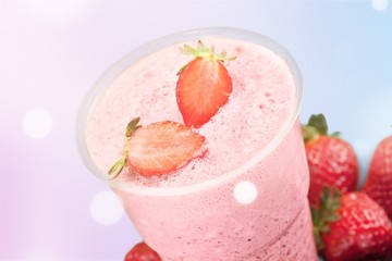 Glass of strawberry smoothie on wooden table