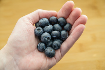 Natural looking blueberries in hand. Selective focus.