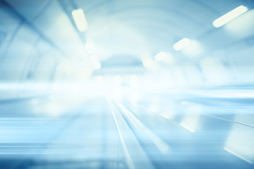 blurred background metro escalator / light blue background movement city infrastructure subway