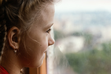 Little girl looking through the window.