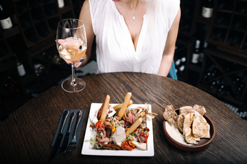 Woman eating tasty salad with food in restaurant