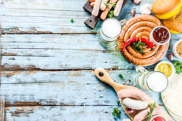 Different bbq picnic party food with beer  various grilled sausages, burger buns, flat taco bread, beer, old wooden background copy space