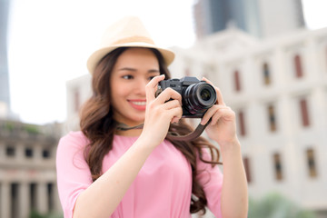 Outdoor summer smiling lifestyle portrait of pretty young woman having fun in the city in Asian with camera travel photo of photographer