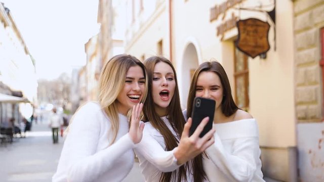 friendship, technology and internet concept - three smiling teenage girls taking picture with smartphone camera at cafe