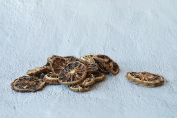 Slices of dried bergamot lying on grey concrete background with copy space, side view