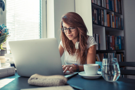 Young Female Curly Hair Student Study At Home.She Using Laptop And Learning Online.