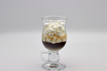 Coffee And Many Small Marshmallows In A Transparent Glass Cup On A Gray Background