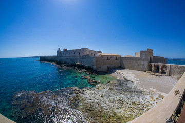 Fototapeta na wymiar fisheye landscape on coast of Ortigia with Castello Maniace at city of Syracuse, Sicily, Italy. 
