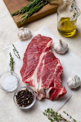 Fresh cut of beef with herbs on light beige background