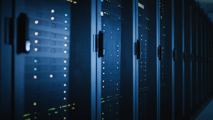 Shot of Dark Modern Data Center With Row of Fully Operational Server Racks. Modern Hi-Tech Concept...