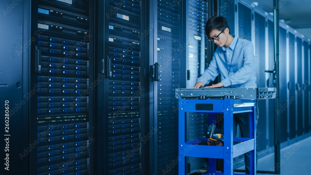 Poster In the Modern Data Center: IT Technician Working with Server Racks, on a Pushcart Various Equipment Needed for Installing New Hard Drives, Doing Hardware Maintenance and Diagnostics.