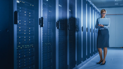 In Data Center: Female IT Technician Running Maintenance Programme on a Laptop, Controls...