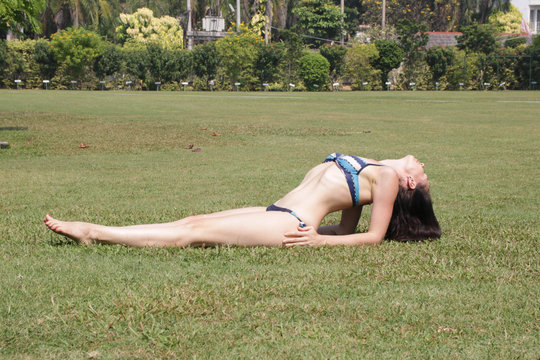 Lesson Yoga outdoors on the grass, Beautiful woman doing matsyasana fish pose on yoga class with copy space