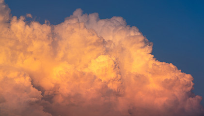 Blue sky and white fluffy clouds on sunset sky. White cumulus clouds. Dramatic sky and clouds abstract background. Warm weather background. Art picture of clouds at dusk. Cloudy sky.
