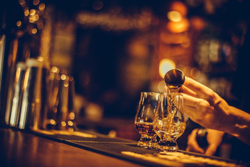 Fototapeta na wymiar Bartender pouring whisky in a glass