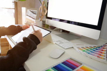 Graphic designer working with tablet in creative workplace