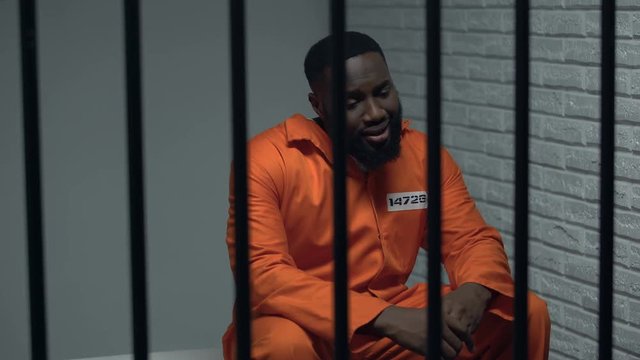 Desperate black prisoner sitting in cell, wrongly accused person, faulty system