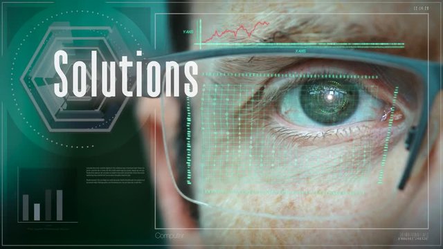 A close up of a businessman eye controlling a futuristic computer system with a Solutions Business concept.