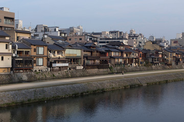 Fototapeta premium View of the Kamo River very early in the morning in Kyoto during the Hanami, typical houses of Kyoto
